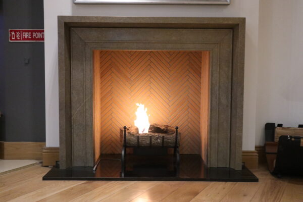 Bespoke Toscana fireplace crafted in Sierra Elvira marble with bioethanol basket fire